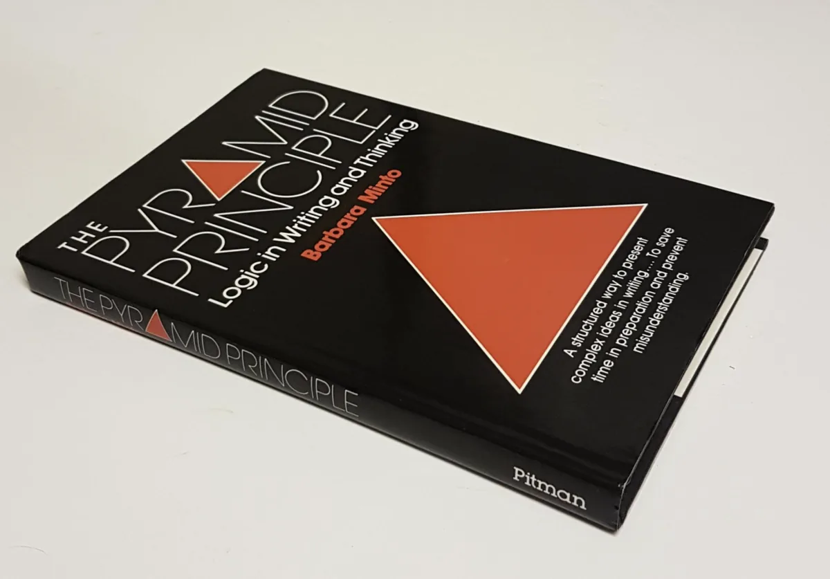 Hardcover copy of The Pyramid Principle: Logic in Writing and Thinking by Barbara Minto — black cover with a red triangle, Pitman edition